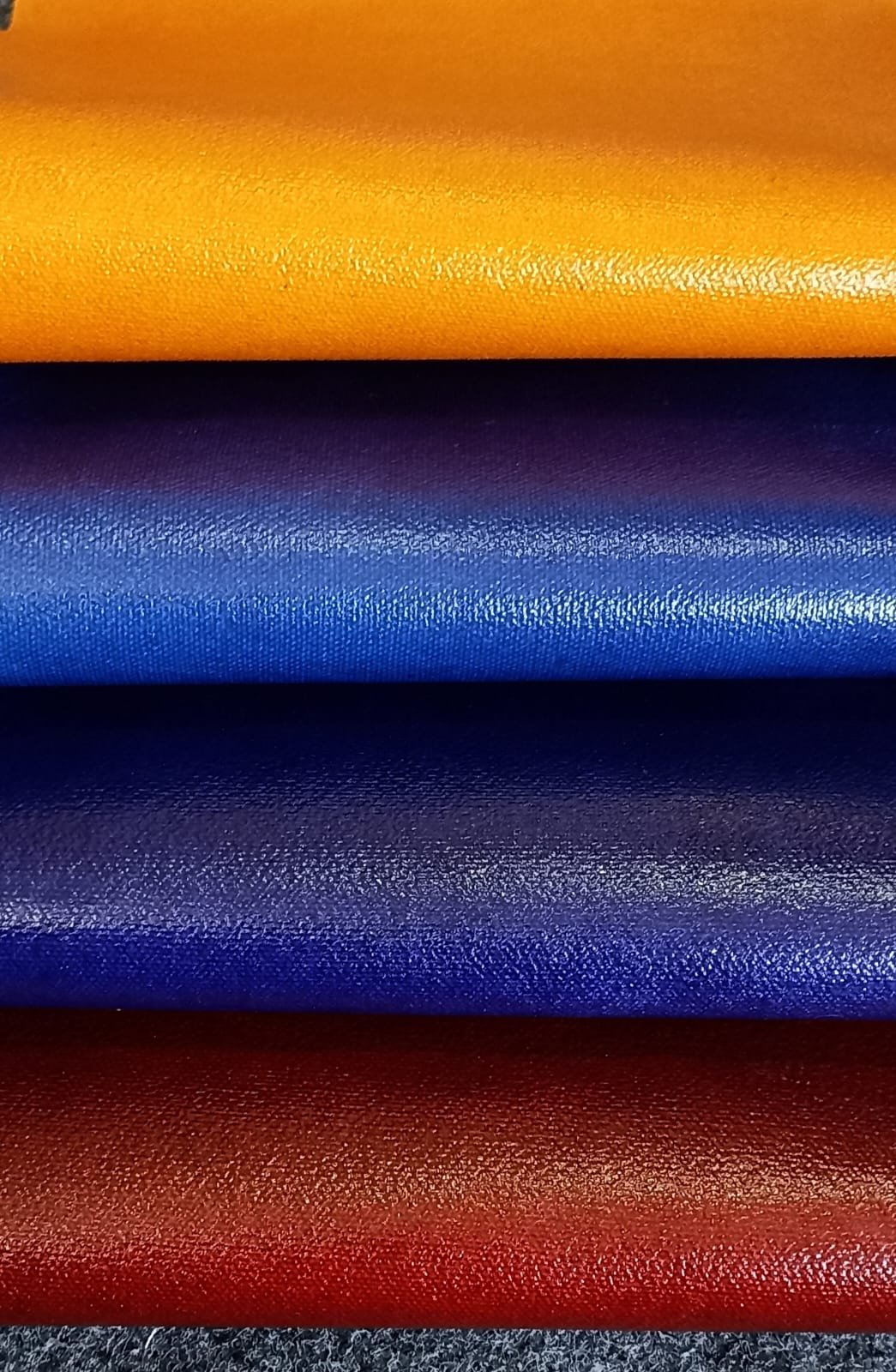 Bioleather logo on a white background with an image of four stacked rolls of vegan leather in vibrant colors: yellow, blue, purple, and red.